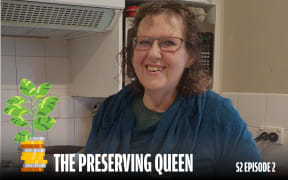 A smiling woman is pictured in front of her oven.