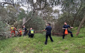 This handout photo taken and released by the Victoria Police on 27 December, 2023 shows emergency workers rescuing a woman from flood waters after heavy rain at the Buchan campground in east Gippsland, east of Melbourne in the Australian state of Victoria. Rescue crews were searching on December 27 for survivors after seven people died in heavy storms across Australia's eastern seaboard, including a 40-year-old woman sucked into a stormwater drain. Rescue crews were searching on for survivors after seven people died in heavy storms across Australia's eastern seaboard, including a 40-year-old woman sucked into a stormwater drain.