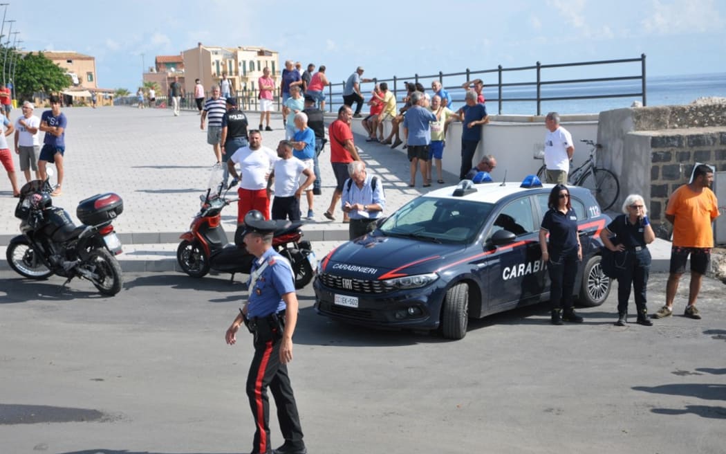 Italian Carabinieri patrol the port as the search continues for six passengers missing from a sailboat that sank off the coast of Porticello, north-western Sicily, on 19 August 2024. One person was killed and rescuers were searching for six others missing after a luxury superyacht 