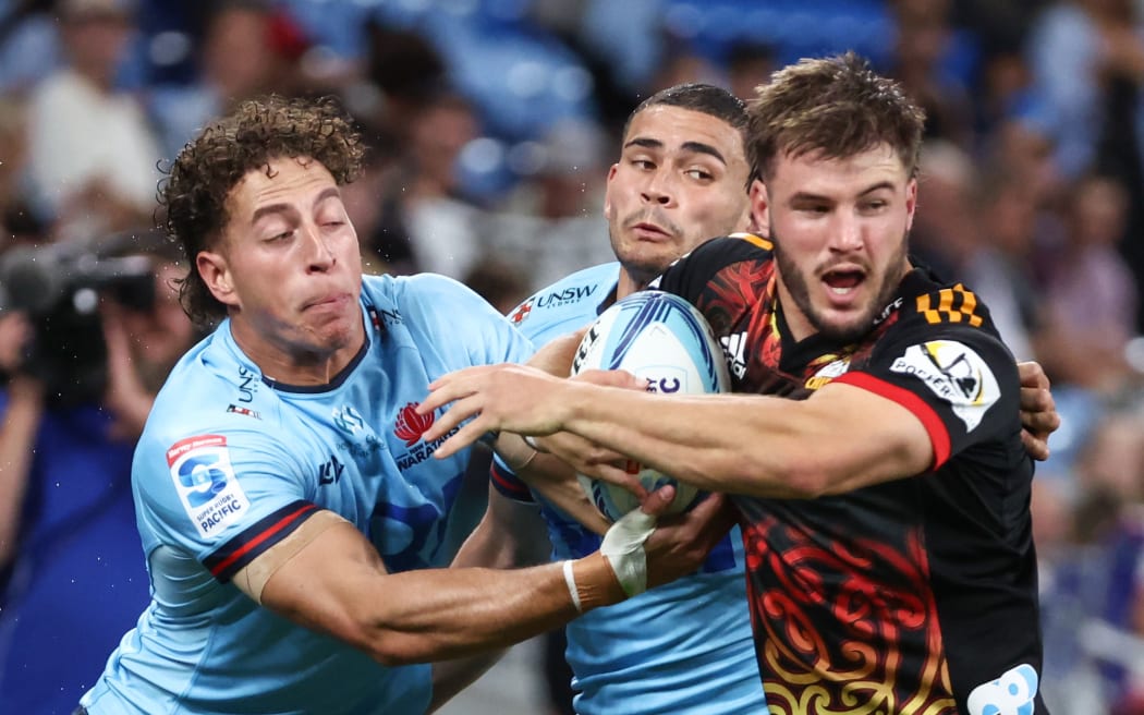 Alex Nankivell of the Chiefs fends off Waratahs defenders.