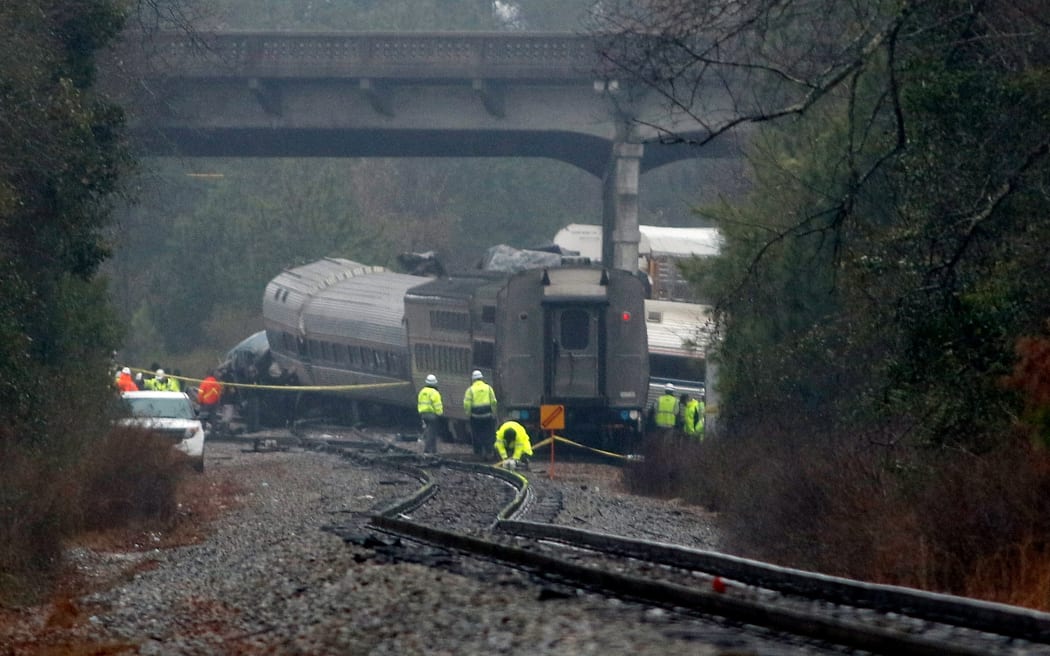 Investigators make their way around the train wreckage under the Charleston Highway overpass where two trains collided early Sunday morning on February 4, 2018 in Cayce, South Carolina. The Amtrak train collided with a freight train.