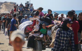 Palestinians make their way along Al-Rashid road toward Gaza City from Nuseirat in the central Gaza Strip on October 10, 2025. Israeli forces declared a ceasefire and withdrew from some positions in Gaza on October 10, as thousands of displaced Palestinians began to trek home and the families of October 7 hostages awaited news. Israeli prime minister's office said that the government had "approved the framework" of a hostage release deal with Hamas, as both sides edged closer to ending more than two years of hostilities in Gaza. (Photo by Bashar TALEB / AFP)