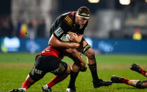 Brodie Retallick of the Chiefs is tackled by Crusader Richie Mo'unga.
