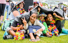 Happy kids in bright clothing under umbrellas