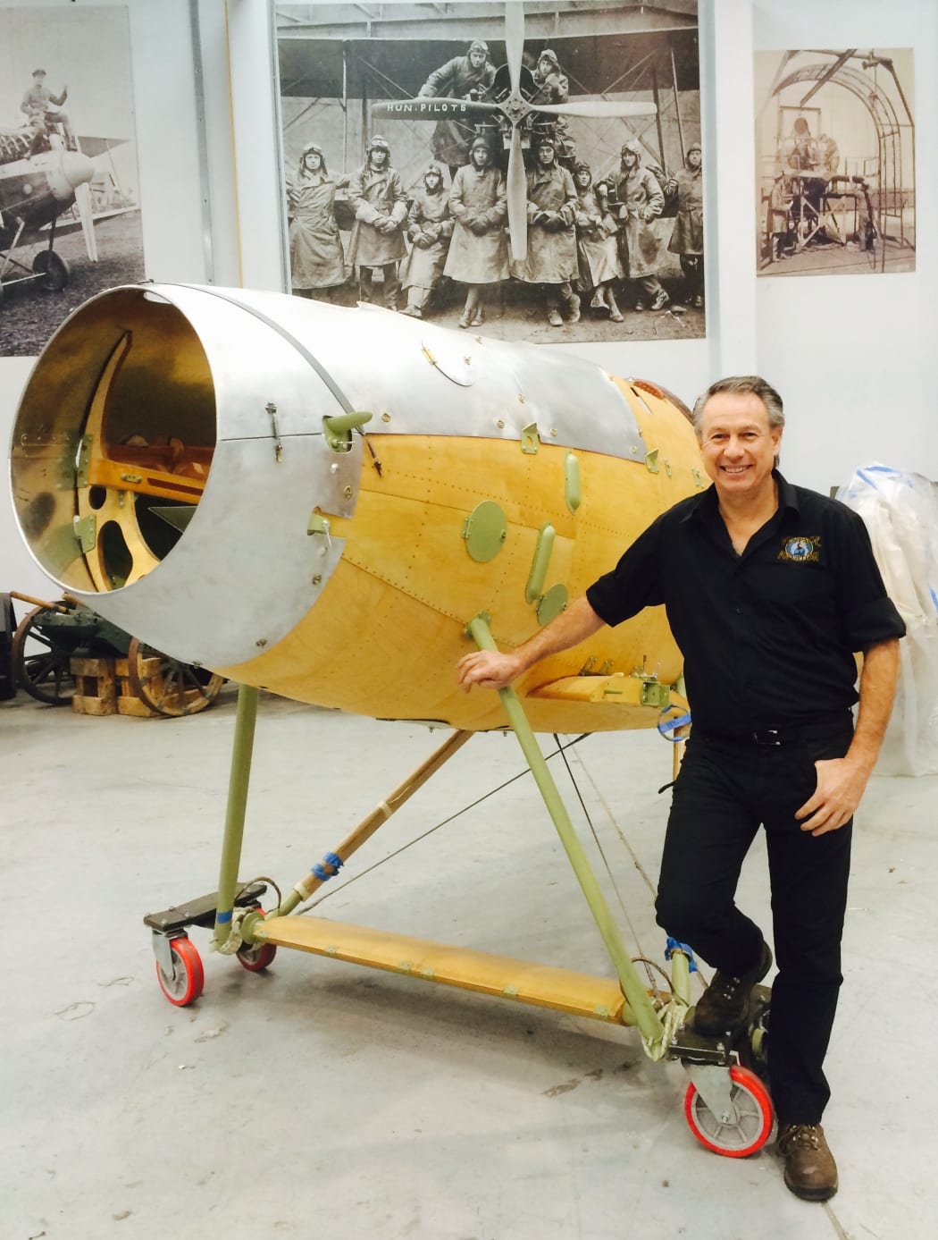 A photo of Gene DeMarco with a partly reconstructed Albatros DVa airplane