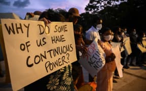 Protesters hold banners and placards during a demonstration against the surge in prices and shortage of fuel and other essential commodities in Colombo on April 1, 2022.