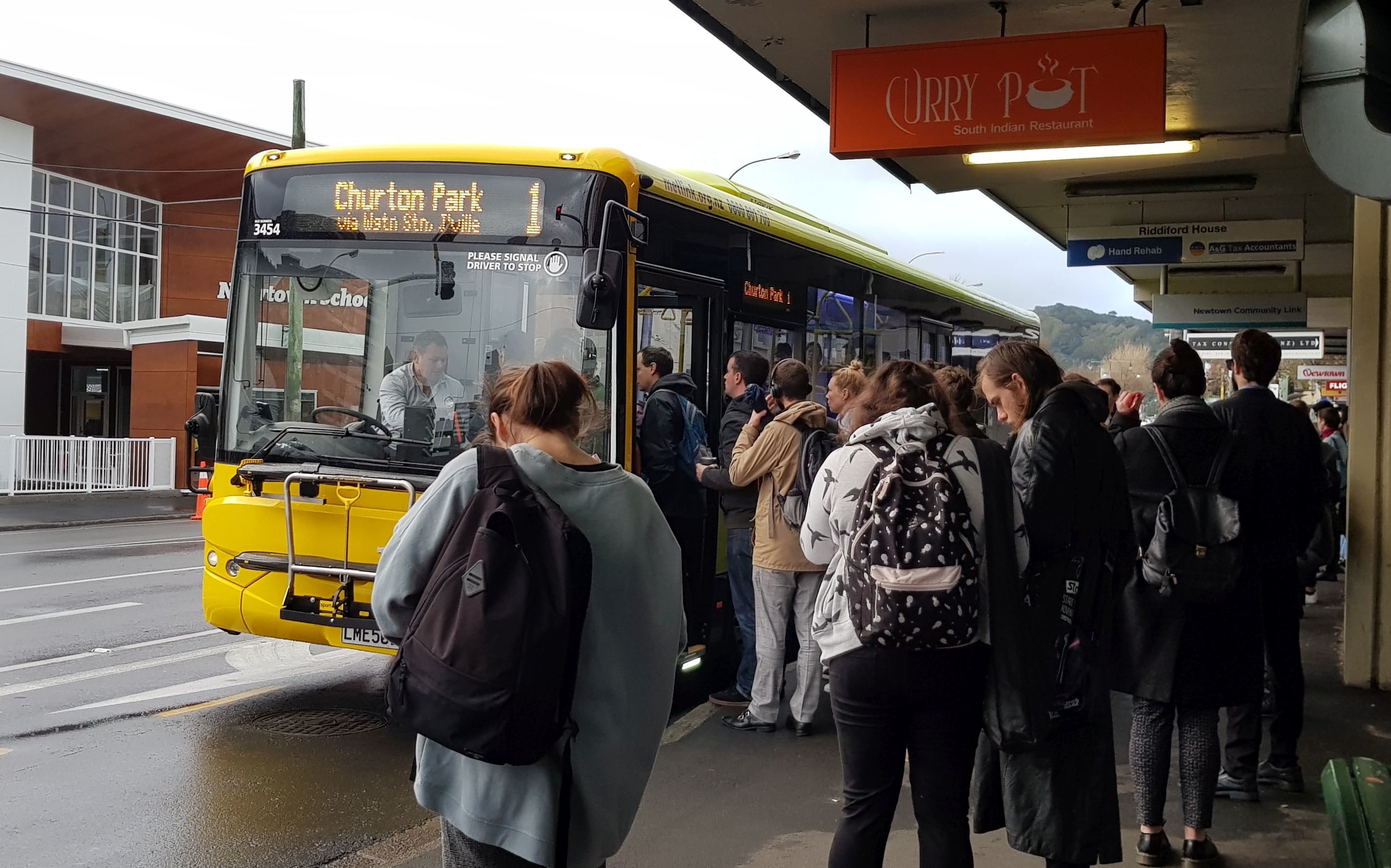Commuters at a bus stop in Newtown