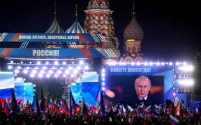 Russian President Vladimir Putin is seen on a screen set at Red Square in central Moscow on 30 September, 2022 as he addresses a rally and a concert marking the annexation of four regions of Ukraine that Russian troops occupy - Lugansk, Donetsk, Kherson and Zaporizhzhia.