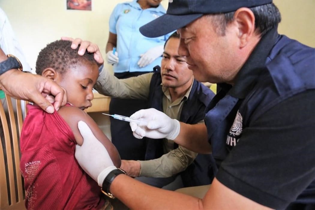 WHO Representative Dr Luo Dapeng administering the measles-rubella vaccine to a child in Jiwaka province.