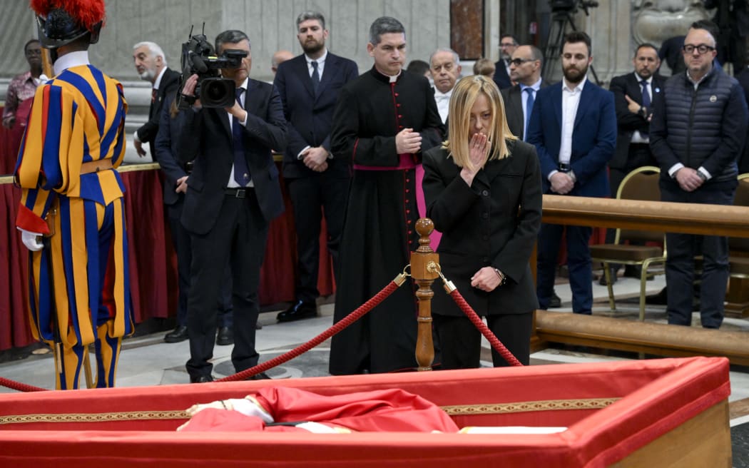 This photo taken and handout on April 23, 2025 by The Vatican Media shows Italy's Prime Minister, Giorgia Meloni paying her respects to Pope Francis at St Peter's basilica in The Vatican. (Photo by Handout / VATICAN MEDIA / AFP) / RESTRICTED TO EDITORIAL USE - MANDATORY CREDIT "AFP PHOTO / VATICAN MEDIA" - NO MARKETING - NO ADVERTISING CAMPAIGNS - DISTRIBUTED AS A SERVICE TO CLIENTS