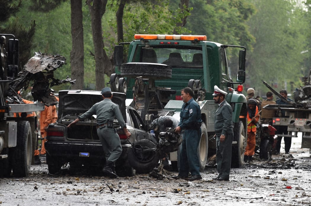 Afghan security personnel investigate the site of a suicide attack that targeted a foreign forces convoy near the US embassy in Kabul on May 3, 2017.