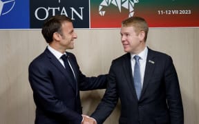 French President Emmanuel Macron, left, shakes hands with New Zealand Prime Minister Chris Hipkins on the sidelines of the NATO summit, in Vilnius on July 11, 2023.