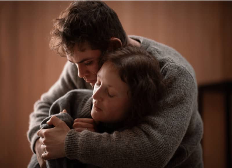 A shot from the film Went Up the Hill of actor Dacre Montgomery holding actress Vicky Krieps.