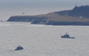 An aerial photo shows a search in Shari Town, Hokkaido Prefecture on April 24, 2022. The Japan Coast Guard said on the same day that it found more than ten people on the sea and on rocks around the tip of Cape Shiretoko, where a sightseeing boat with 26 people aboard went missing.