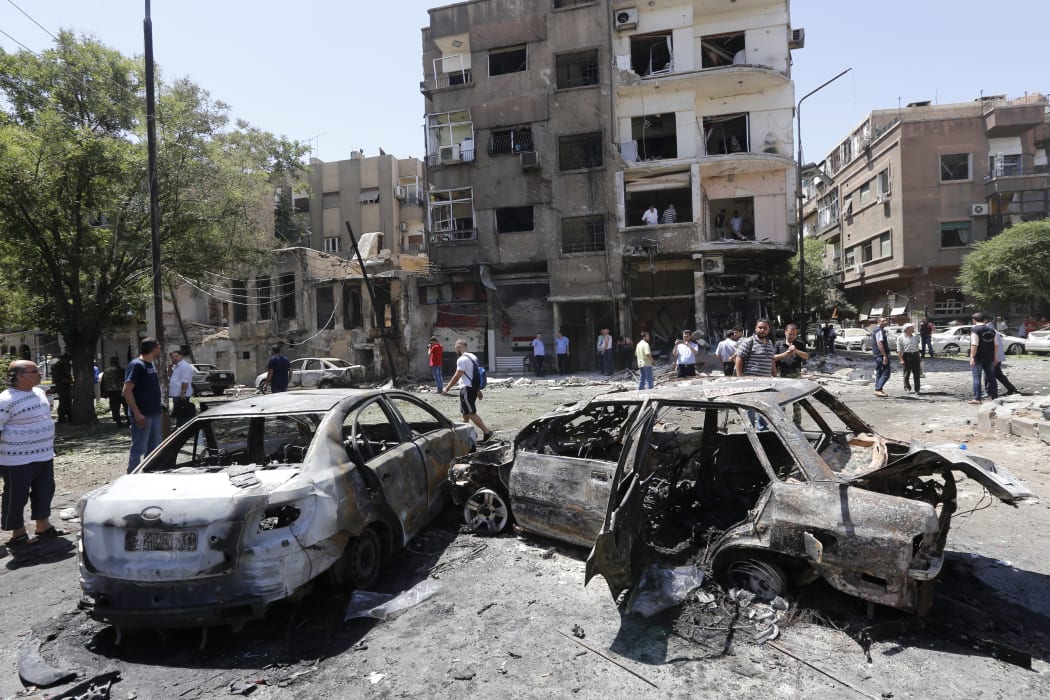 Charred vehicles at the site of a suicide bomb attack in the Syrian capital Damascus.