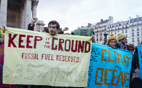Campaigners urge companies at the  Paris summit to phase out fossil fuels.