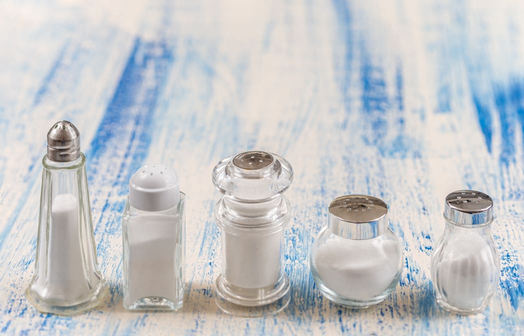 Salt shakers 
Fine salt under various transparent glass salt shakers aligned in the foreground. (Photo by CHASSENET / BSIP / BSIP via AFP)