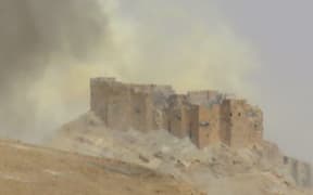 Smoke billows from the Palmyra citadel as Syrian troops retake the ancient city from Islamic State.