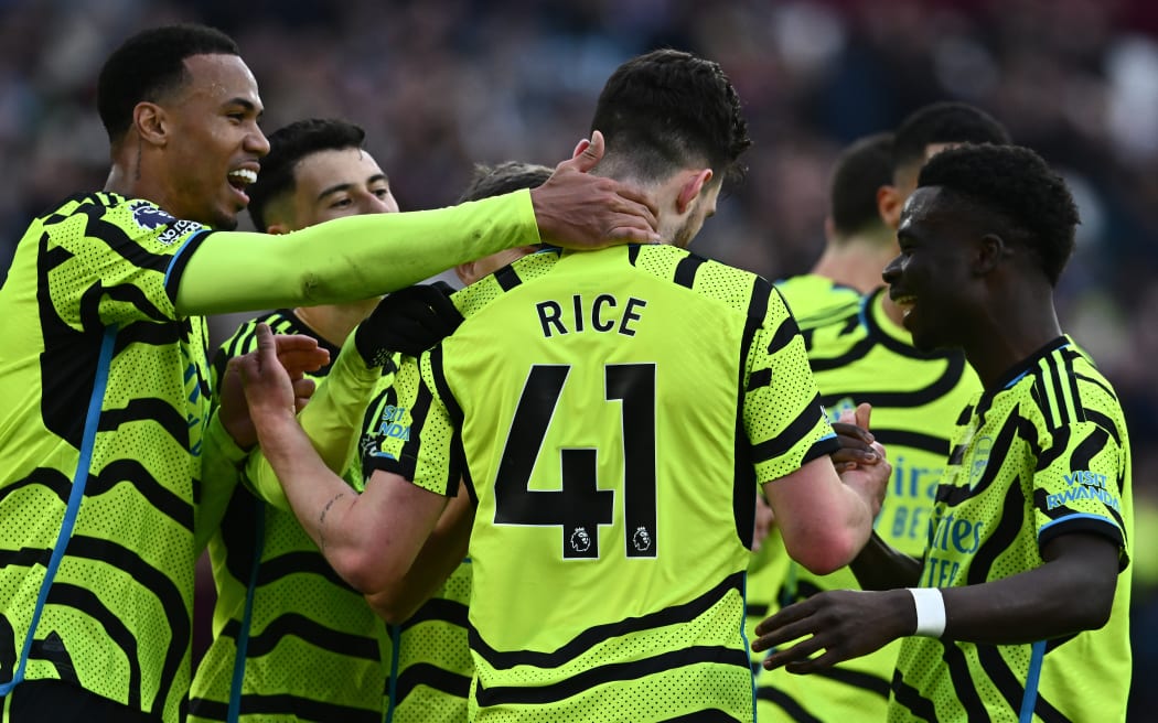 Declan Rice of Arsenal FC celebrates with Gabriel Magalhaes and Bukayo Saka.