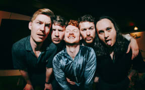 The band castaway are huddles together and pulling semi-silly faces at the camera.