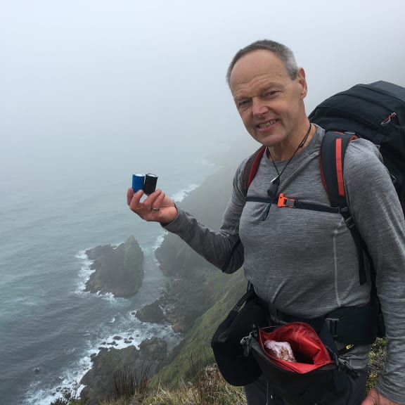 Bruce Hopkins at Cape Reinga holding the ashes of his father and brother.