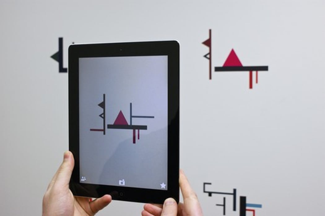 An image of a digital device held up to reveal an artwork by Shannon Novak. the work is called String Section.