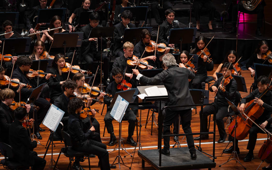 NZSO National Youth Orchestra with conductor Adam Johnson onstage at Wellington's Michael Fowler Centre.