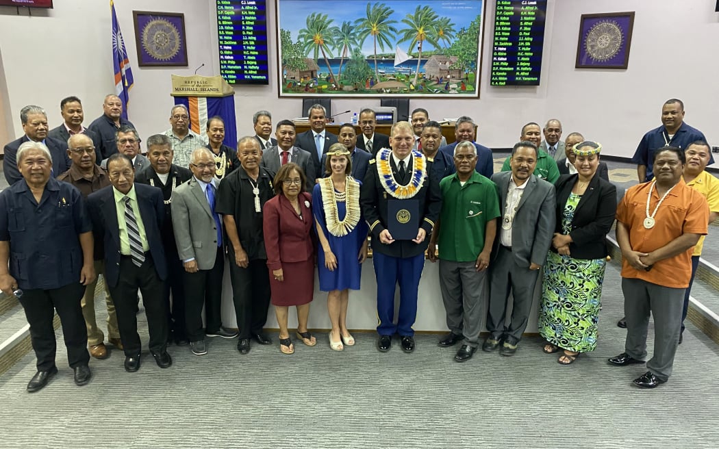 Following an extended and unprecedented ceremony to honor US Army Col. Jeremy Bartel, center, with US Ambassador Roxanne Cabral to his right,and the entire membership of the Nitijela (parliament)