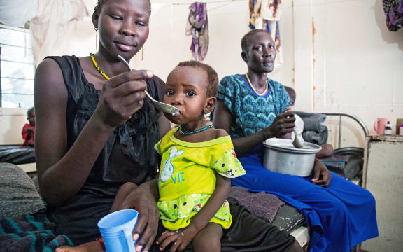 A mother gives food to her child with malnutrition in a clinic in Old Fangak, Jonglei state