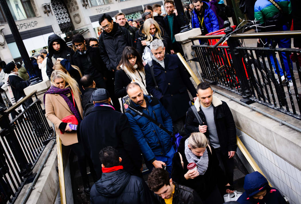 A crowd of people descend into Oxford Circus station in London, England, on February 9, 2019.