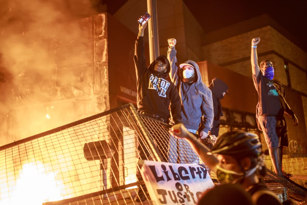 Protesters in front of the burning Third Police Precinct in Minneapolis, in a third day of demonstrations over the police killing of George Floyd.