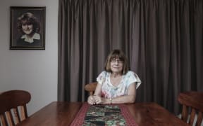 Robyn Jensen at home, 2017, under a photo of her missing daughter Kirsa.