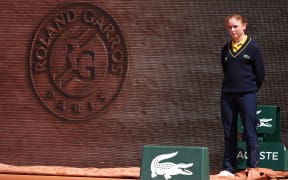 A line judge stands on the side of the court during the women's singles match between Poland's Iga Swiatek and Slovakia’s Rebecca Sramkova on day 2 of the French Open tennis tournament on Court Philippe-Chatrier at the Roland-Garros Complex in Paris on May 26, 2025. (Photo by Dimitar DILKOFF / AFP)