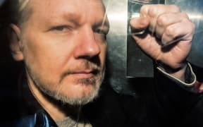 WikiLeaks founder Julian Assange gestures from the window of a prison van as he is driven into Southwark Crown Court in London on May 1, 2019, before being sentenced to 50 weeks in prison for breaching his bail conditions in 2012.