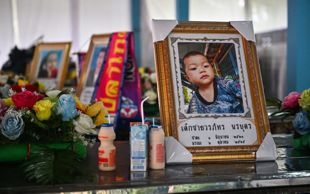 The portraits of those killed in a mass shooting in a nursery are seen atop their coffins at Wat Si Uthai temple in Thailand's northeastern Nong Bua Lam Phu province on October 8, 2022.