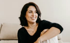A smiling woman in a black top.