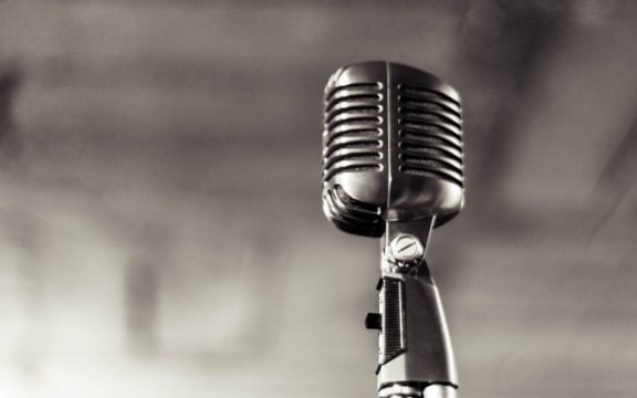 Black and white picture of an old 1960s style microphone on a stand