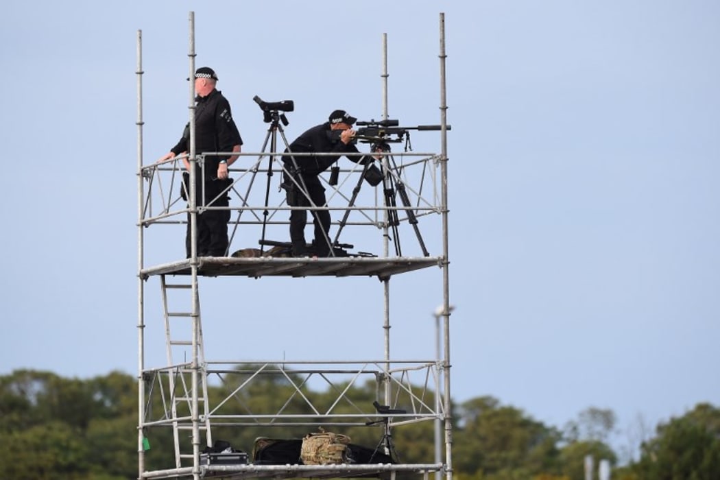 Police marksmen await the arrival of US President Donald Trump on Air Force One at Prestwick Airport.