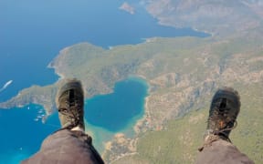 A paraglider with the Earth below his feet.