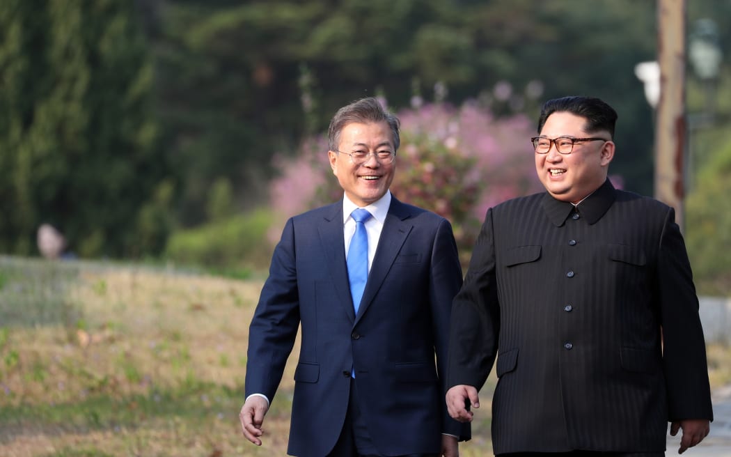 North Korea's leader Kim Jong Un (R) and South Korea's President Moon Jae-in (L) walk together after a tree-planting ceremony