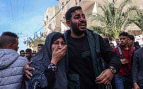 Relatives react after the body of a victim was found after a reported Israeli bombardment hit a car in Rafah in the southern Gaza Strip on January 8, 2024 amid continuing battles between Israel and the militant group Hamas. (Photo by AFP)