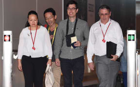 Australian student Alek Sigley (C) smiles as he arrives at Haneda International airport in Tokyo on July 4, 2019, following his release. -