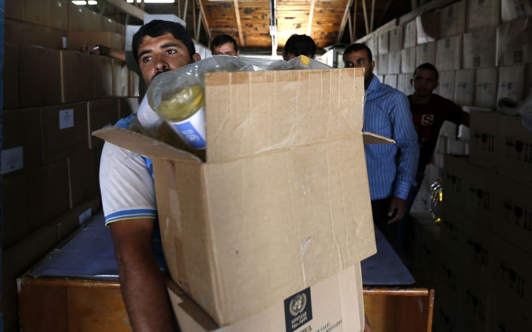 A Palestinian man carries boxes of goods received at an aid distribution centre of the UN's Relief and Works Agency in Gaza City this month.
