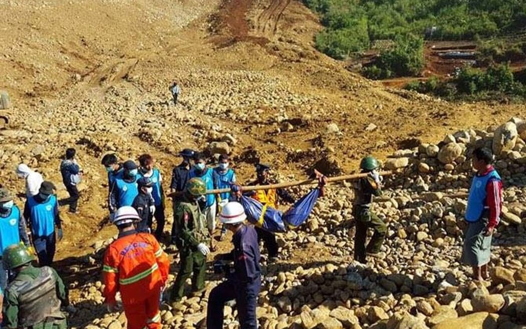 Search and rescue teams remove a body from the scene of a a huge landslide at a jade mine in northern Myanmar.