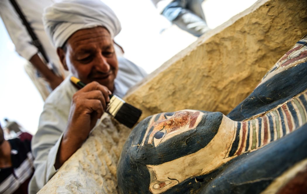 A man brushes off dust from a sarcophagus, 300 meters south of King Amenemhat IIs pyramid at Dahshur necropolis, exposed near the Bent Pyramid, about 40km  south of Cairo, during an inaugural ceremony of the pyramid and its satellites, on July 13, 2019.