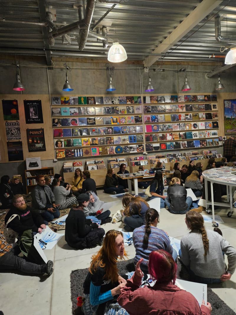 Dozens of listening party patrons sit down as Lorde’s album begins at Flying Nun in Christchurch.