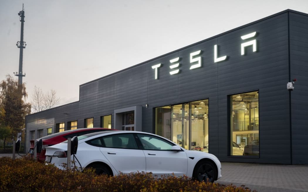 12 November 2021, Lower Saxony, Hanover: Cars park past a dealership of electric car maker Tesla. Tesla's stock has gained about 50 percent since the beginning of the year.