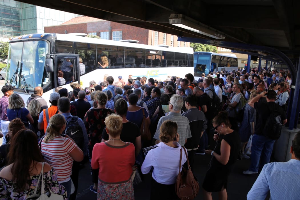 Commuters in Wellington wait for buses after a power outage cut most train services out of the region.