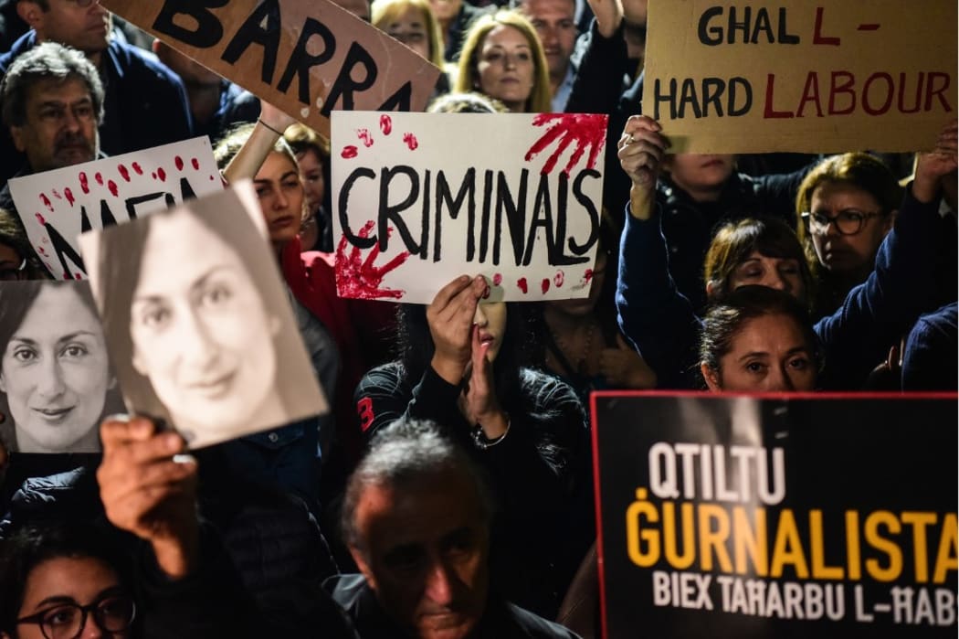 People holding placards and photos of killed journalist Daphne Caruana Galizia, stage a protest called by Galizia's family and civic movements, on November 29, 2019 outside the office of the prime minister in Valletta, Malta.