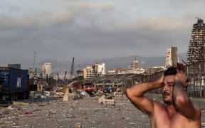 A man reacts at the scene of an explosion at the port in Lebanon's capital Beirut.
